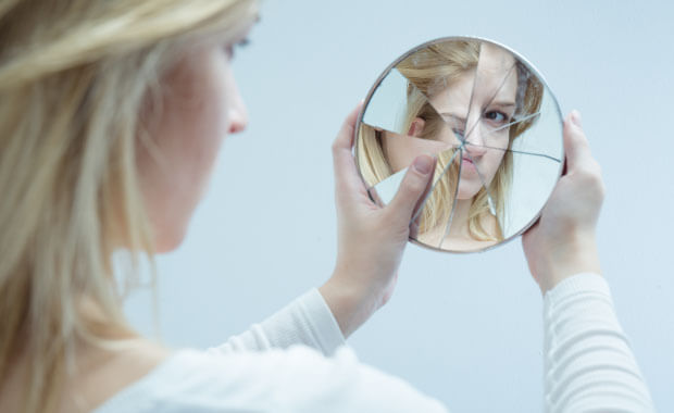 documenting low self-esteemwith young women looking into a broken mirror