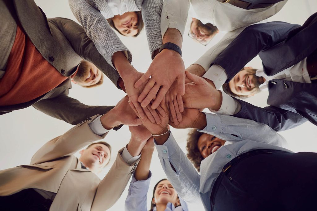 Mental Status Exam Cultural Competency expressed through diverse group in a circle laying hands in the middle